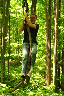 Anthony climbing a vine in the woods