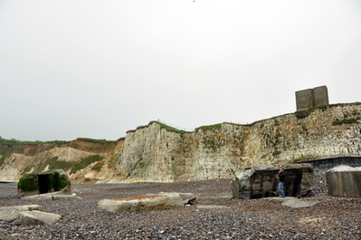 Anthony pointing at WWII German pillboxes, some of which used to be on the cliff but have since fallen down to the beach