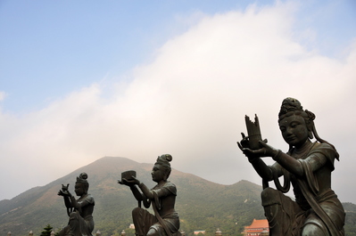 Statues making offerings to the Buddha