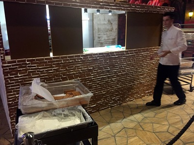 Man at a casino building a lifesize gingerbread house out of real gingerbread and icing