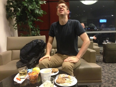 In the United Lounge in front of a pile of food and looking crazy